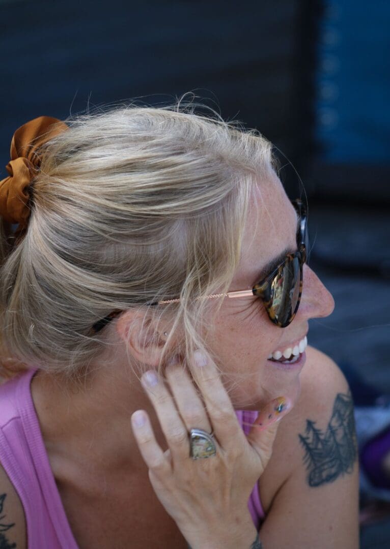 A woman with sunglasses and a ring on her finger.